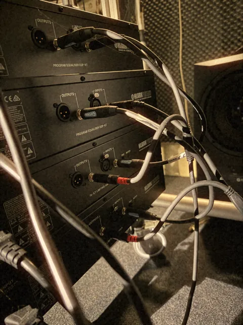 Rack gear and cables behind the studio desk